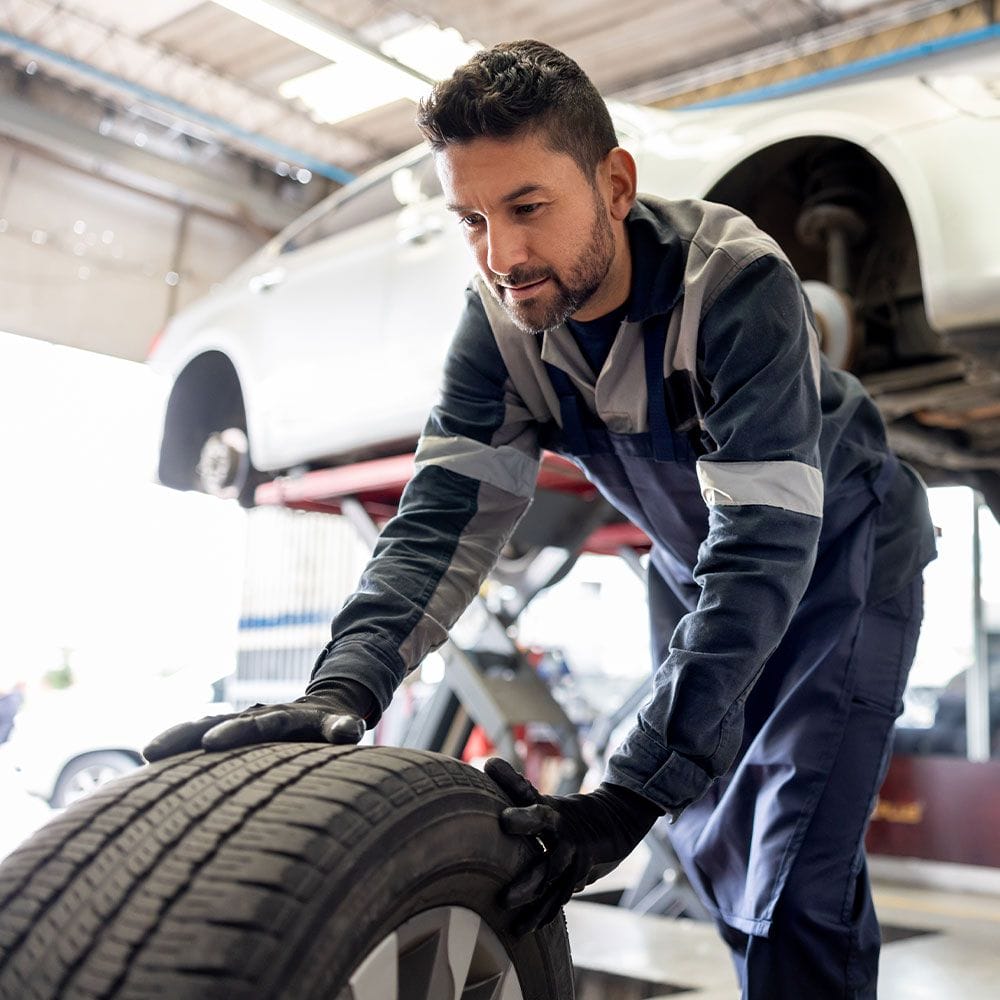Automotive employee changing tire