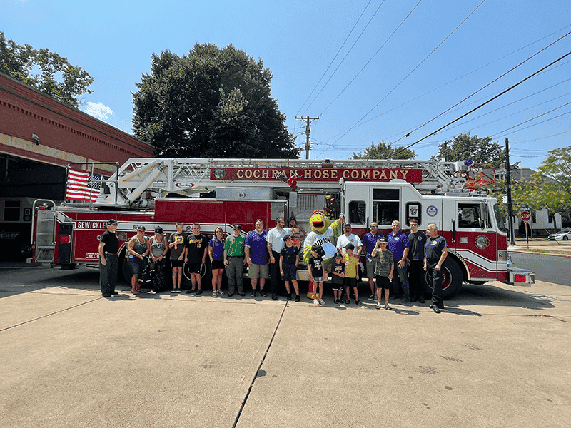 Guardian Protection employees in front of local firetruck with the Pirate Parrot