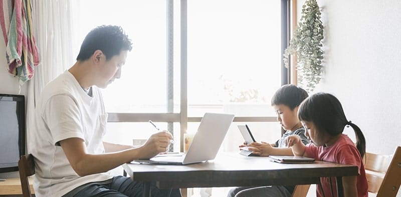 father working remotely with children
