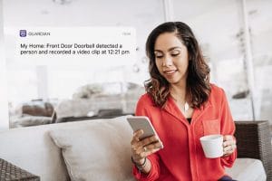 Woman sitting on the couch looking at security notification on her smart phone