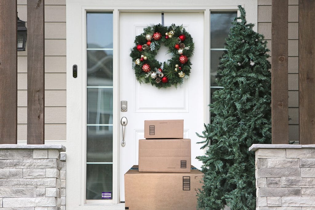 Front porch decorated in holiday decor with a Guardian Protection Video Doorbell Pro mounted by the door