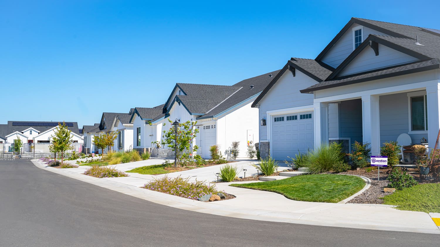 Outside of homes protected by Guardian Protection with yard sign in lawn