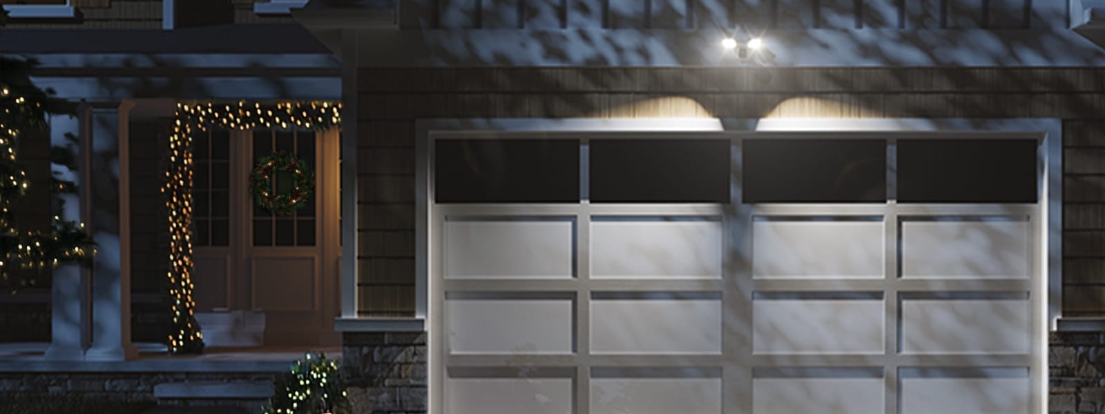 Home decorated with holiday lights with a Guardian Protection floodlight security camera installed above the garage door.