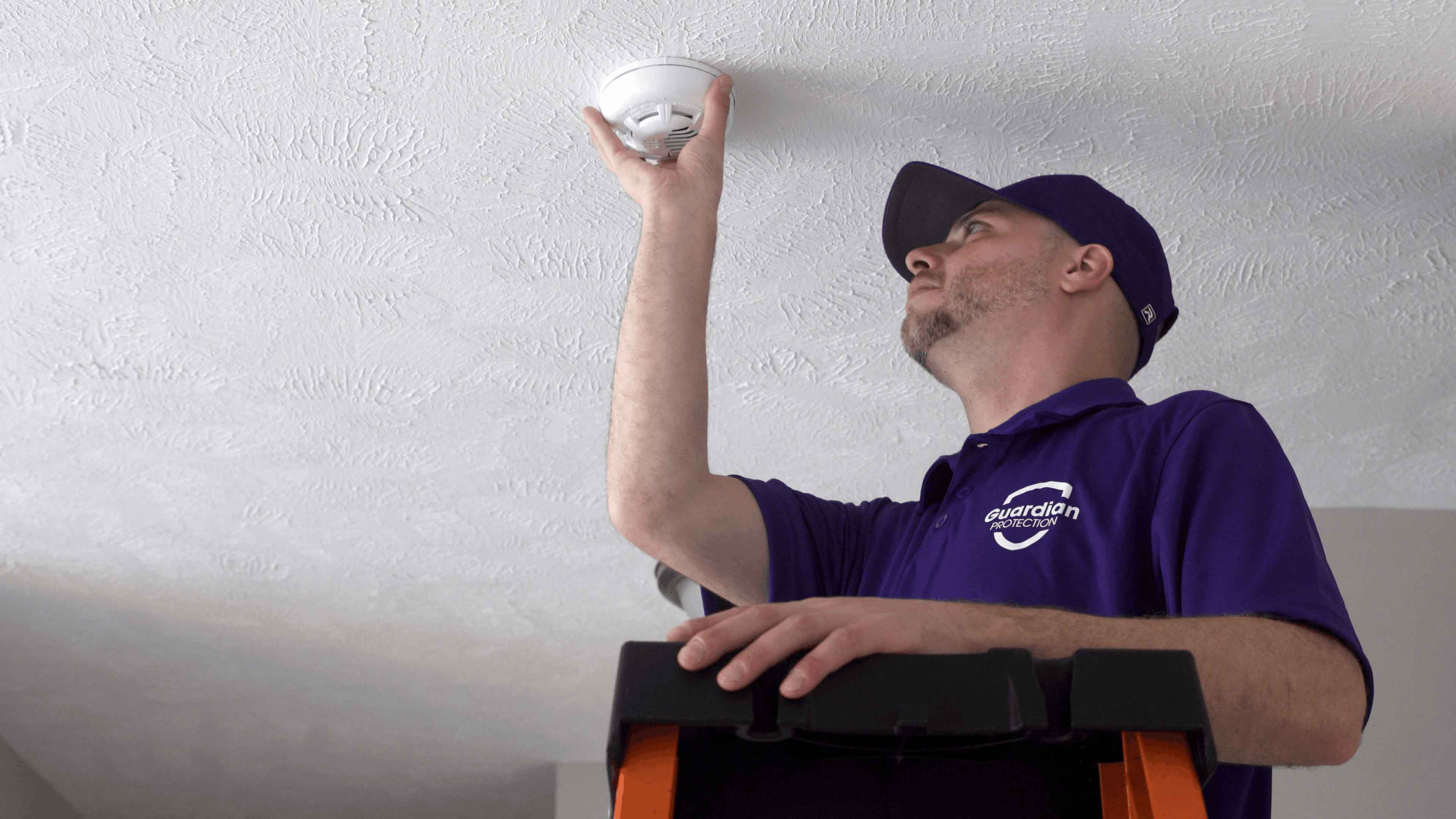 Guardian Protection technician installing a monitored smoke alarm